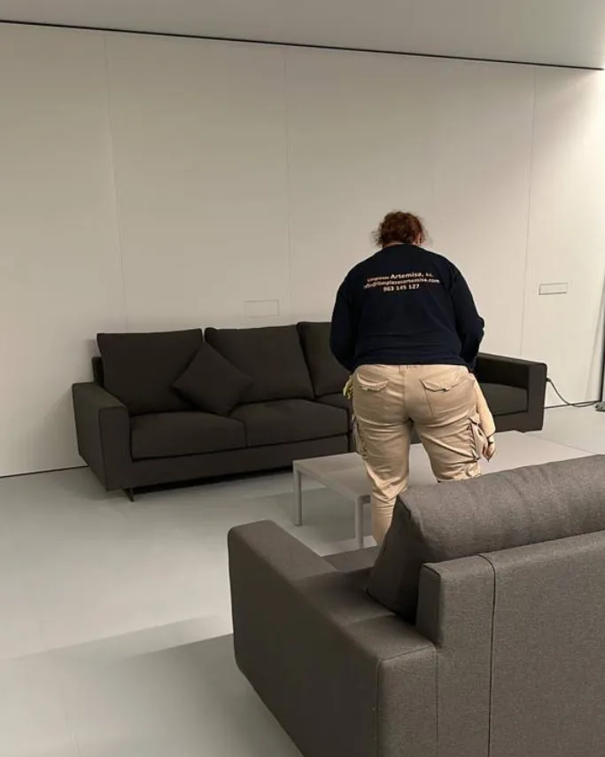 Trabajadora de Limpiezas Artemisa, con la sudadera de la empresa, limpiando un salón