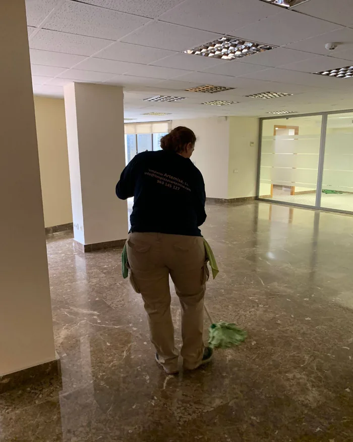Trabajadora de Limpiezas Artemisa fregando el suelo de mármol de una oficina diáfana